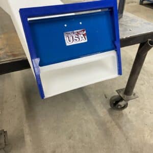 A blue and white portfolio tray sitting on a table in a workshop.